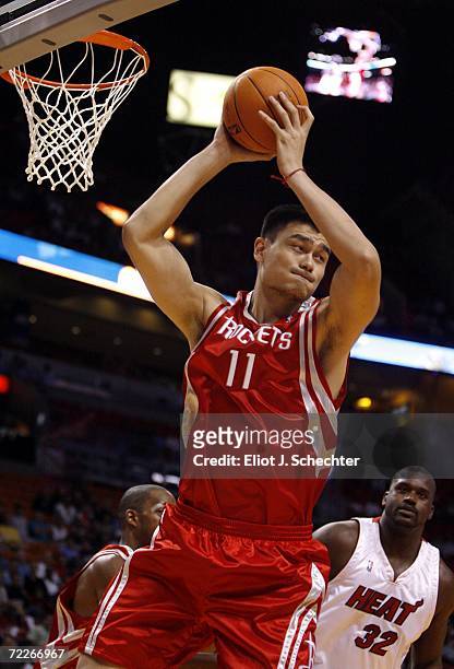 Center Yao Ming of the Houston Rockets pulls down a rebound with Shaquille O'Neal of the Miami Heat near by during their preseason game on October...