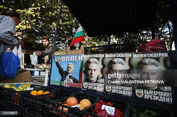 Street vendor works on his fruit and vegetable stall decorated with pre-election campaign posters of ultra-nationalist candidate Volen Siderov in...