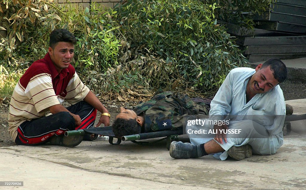 Relatives of an Iraqi policeman weep bes