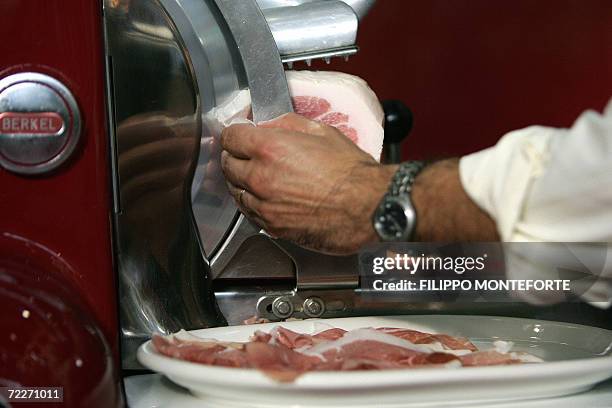 An exhibitor carves Prosciutto at the Salone del Gusto, 26 october 2006 in Turin. The Slow Food movement kicks off its second world gathering, with...