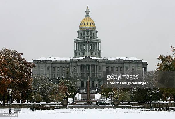 The Colorado State Capitol Building stands across a snow covered Civic Center Park after an early season snowstorm on October 26, 2006 in Denver,...