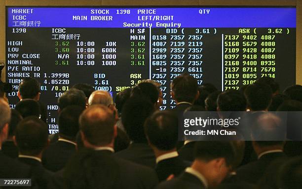 Guests look at the electronic billboard showing the Industrial and Commercial Bank Of China's stock price after the ceremony to mark their Initial...