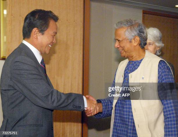 Nobel Peace Prize winner and founder of the Grameen Bank Muhammad Yunus of Bangladesh shakes hands with Japanese Foreign Minister Taro Aso prior to...