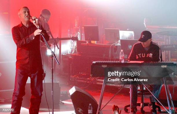 Chris Lowe and Neil Tennant of the music group Pet Shop Boys perform on stage under red lights at Club Acualung June 12, 2002 in Madrid, Spain.