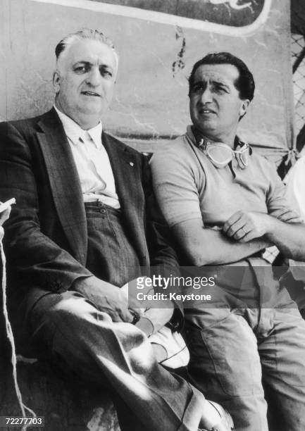 Italian car manufacturer Enzo Ferrari and one of his drivers, Alberto Ascari talk over their strategy for the Italian Grand Prix in the pits at...