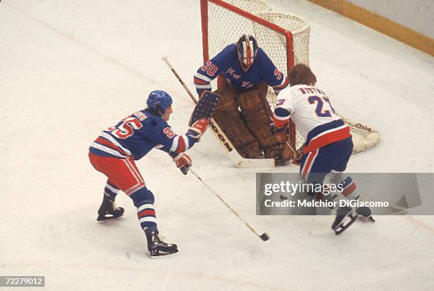 Swedish hockey player Bob Nystrom of the New York Islanders tries to slip the puck past Canadian hockey player John Davidson, goalkeeper for the New...