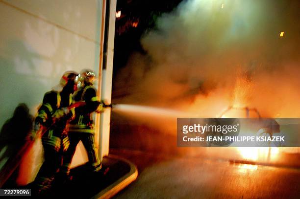 Firemen try to extinguish a car set ablaze earlier by youth, 27 October 2006 in Venissieux South east France. The move came on the one-year...