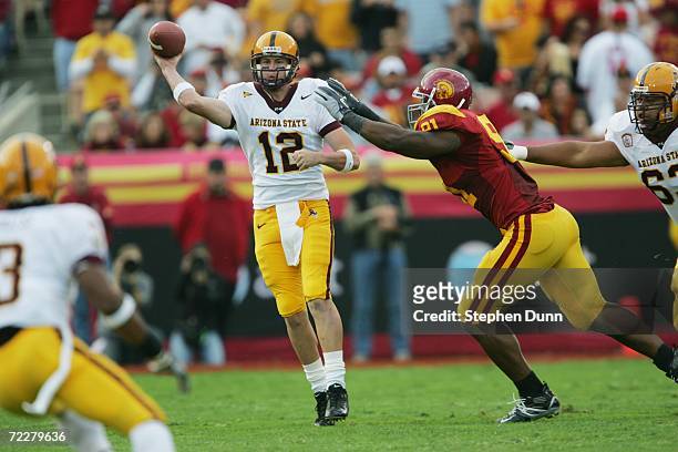 Quarterback Rudy Carpenter of the Arizona State Sun Devils throws under pressure from defensive tackle Chris Barrett of the USC Trojans at the Los...