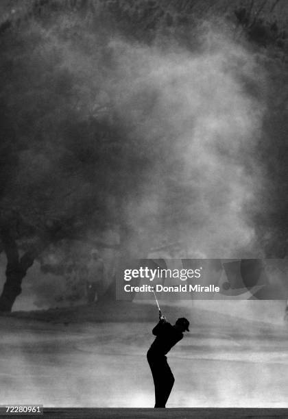 Davis Love III hits off the 1st fairway in mist in the first 18 holes of the final round against Tiger Woods during the WGC- Accenture Match Play...