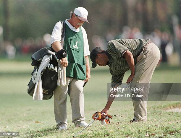 Tiger Woods measures one club length for a drop after hitting into a water hazard on the second hole during the second round of the 1996 PGA Tour...