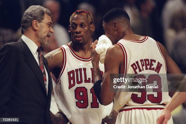 Dennis Rodman Scottie Pippen of the Chicago Bulls listen to head coach Phil Jackson during the game against the Charlotte Hornets at the United...