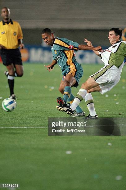 Robin Fraser of the Los Angeles Galaxy kicks the ball as Chad Deering of the Dallas Burn is next to him during the game at the Rose Bowl in Pasadena,...