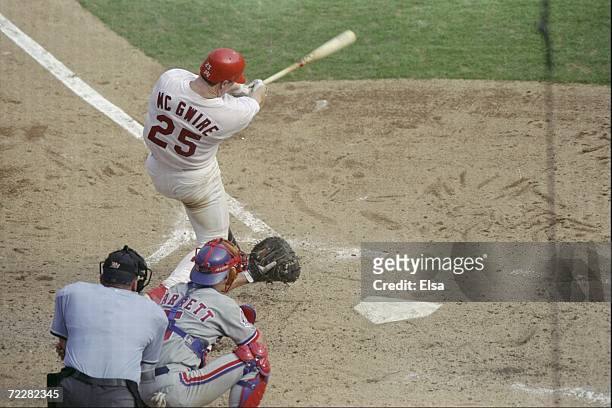 Mark McGwire of the St. Louis Cardinals hits his 70th home run of the season during a game against the Montreal Expos at the Busch Stadium in St....