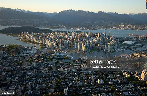 An aerial sunset view shows both the city's downtown as well as the huge green expanse to its north that is Stanley Park, one of the city's 180...