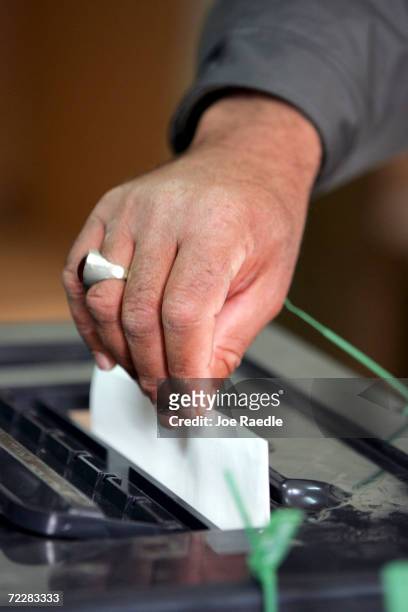 An Iraqi man drops his ballot into the ballot box after voting inside a polling station January 30, 2005 in Ramadi, Iraq. Iraq 's first multiparty...