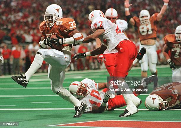 Running Back Priest Holmes of the University of Texas Longhorns high steps into the end-zone past Ralph Brown and Mike Minter of the University of...