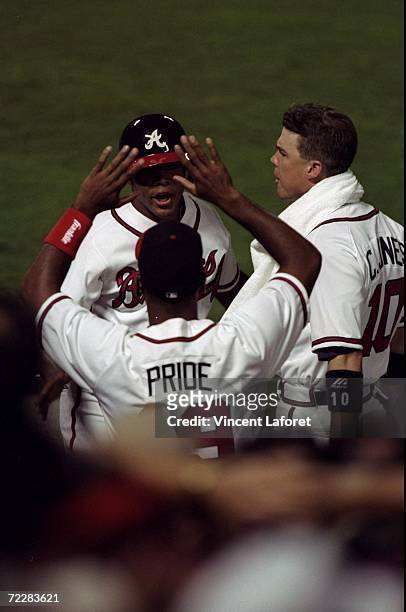 Outfielder Andruw Jones of the Atlanta Braves is greeted by teammates during the National League Championship Series game against the San Diego...