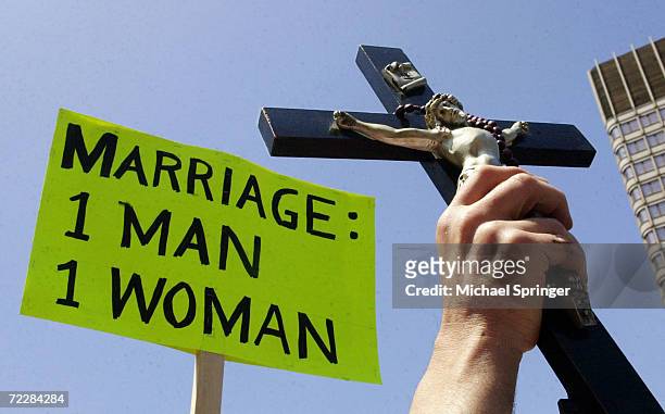 Opponents of same-sex marriage hold up a sign and a crucifix during a rally outside City Hall May 17, 2004 in Boston, Massachusetts. Inside the...