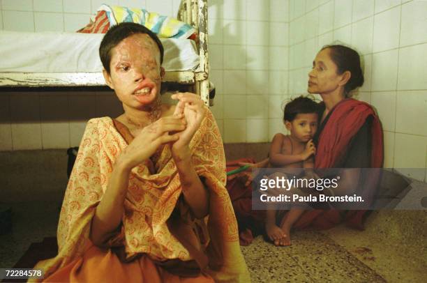 Popi, a 22 year-old Bangladeshi woman, sits in a hospital in Dhaka, Bangladesh after she was attacked with battery acid while on a rickshaw. Popi was...