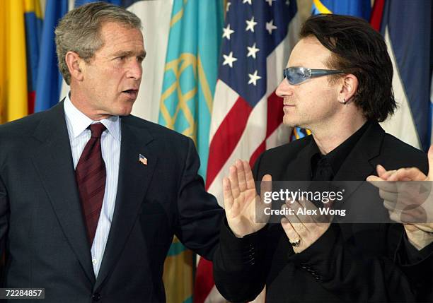 President George W. Bush speaks with Bono, the lead singer of Irish pop group U2, March 14, 2002 during an Inter-American Development Bank event on...