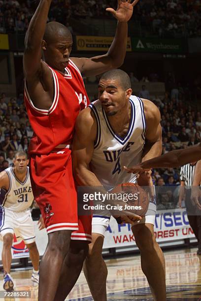 Center Carlos Boozer of the Duke Blue Devils tries to hang onto the ball as forward Marlone Jackson of the Lamar Cardinals defends during their...