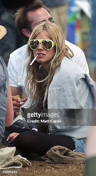 Sienna Miller takes a break during the third and final day of the Glastonbury Festival 2004 at Worthy Farm, Pilton on June 27, 2004 in Somerset,...