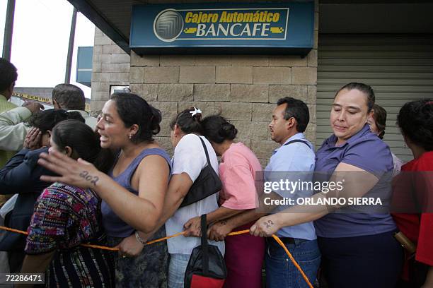 Depositantes se aglomeran en un cajero automatico de Banco del Cafe S.A. Para retirar sus fondos en Ciudad de Guatemala, el 27 de octubre de 2006....