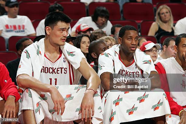 Yao Ming and Tracy McGrady of the Houston Rockets look on from the bench area during the preseason game against the San Antonio Spurs at the Toyota...