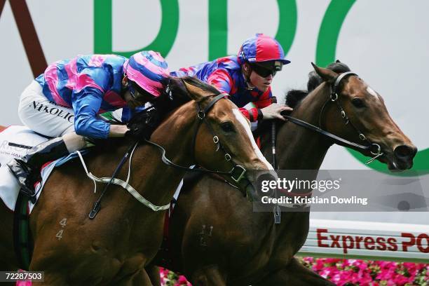 Craig Williams riding Cinq Rouge passes Danny Nikolic riding Royal Asscher to win the Arrow Training Services Stakes during the Cox Plate meeting at...