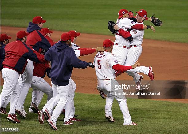Closing pitcher Adam Wainwright, catcher Yadier Molina and the St. Louis Cardinals celebrate the final out of their 4-2 victory to win the World...