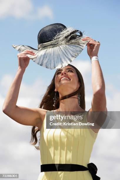 Actress Jolene Anderson adjusts her hat at the "Fashions on the Field" competition during the Cox Plate meeting at Moonee Valley Racing Club on...