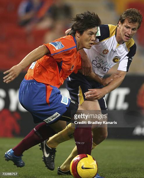 Yuning Zhang of the Roar is challenged by Alex Wilkinson of the MAriners during the round ten Hyundai A-League match between the Queensland Roar and...