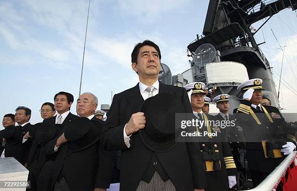 Japanese Prime Minister Shinzo Abe salutes with officials while assisting at the Fleet Review of the Japan Maritime Self-Defense Force on October 29,...