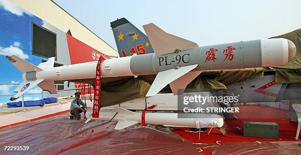 Security guard sits behind a Chinese-made L15 advance trainer jet on display for the 6th China International Aviation and Aerospace Exhibition in...