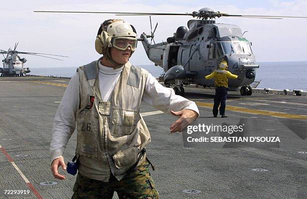 Naval crew member signals to clear the deck for a helicopter landing aboard American assault war ship USS Boxer LHD 4 during the ninth Indo-US joint...