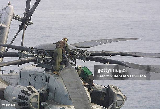 Crew members of the USS Boxer LHD 4 carry out mantainance of a DC3 Orion Anti-submarine helicopter during the ninth Indo-US joint excercise...