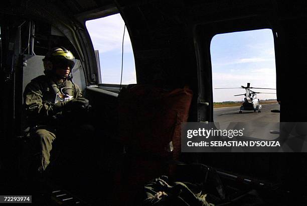 Navy helicopter crew member watches as his aircraft taxis before take-off from the Indian naval air-base Hansa during the ninth Indo-US joint...