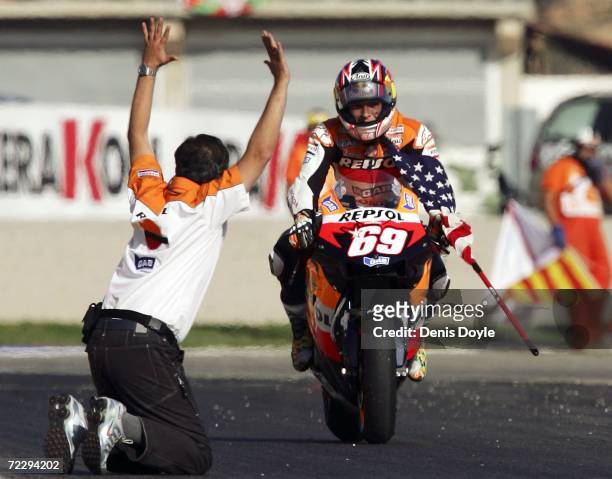 Man waves to Nicky Hayden of the U.S. As he clinches the World MotoGP title after finishing third in the MotoGP race in the Ricardo Torma racetrack...