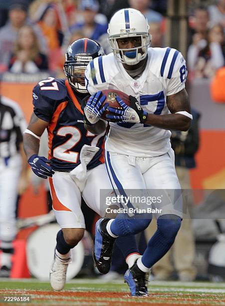 Wide receiver Reggie Wayne of the Indianapolis Colts catches a touchdown pass against cornerback Darrent Williams of the Denver Broncos in the third...