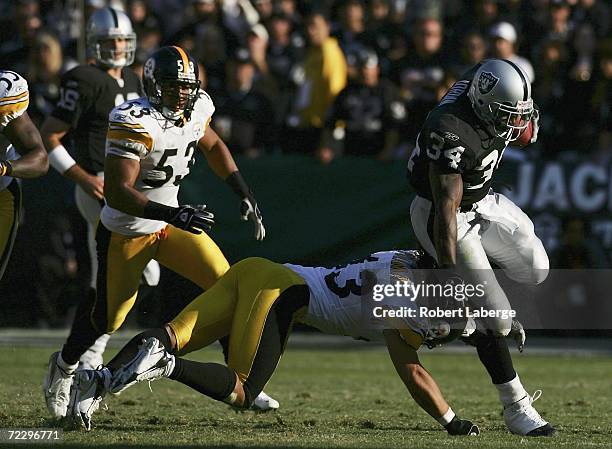 LaMont Jordan of the Oakland Raiders is tackled by Troy Polamalu of the Pittsburgh Steelers as Clark Haggans looks on during an NFL game on October...