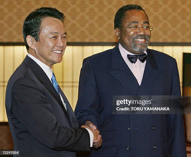 Japanese Foreign Minister Taro Aso shakes hands with his Congolese counterpart Rodolphe Adada at the Iikura guesthouse in Tokyo, 30 October 2006....