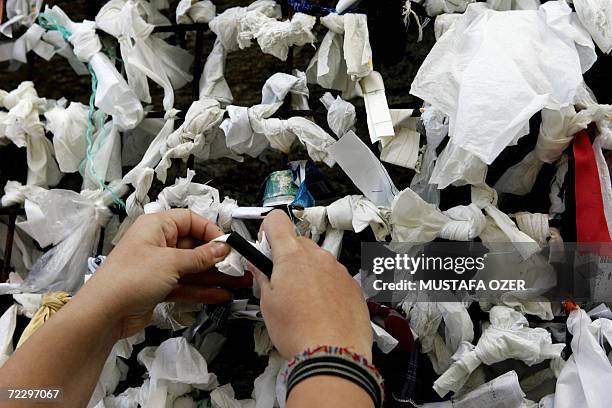 Visitor ties a piece of paper onto a wish wall at the house of Virgin Mary near the Ephesus, 95 kms from the western coastal city of Izmir, 29...