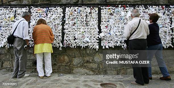 Visitors tie pieces of paper onto a wish wall at the house of Virgin Mary near the Ephesus, 95 kms from the western coastal city of Izmir, 29 October...