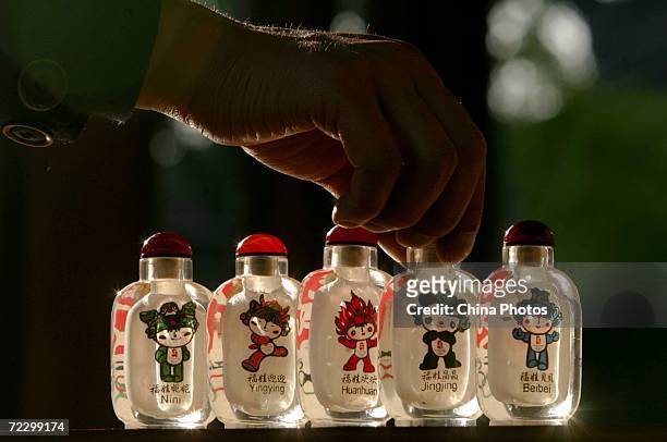 Interior painting artist Li Junyu displays his artworks of snuff bottles October 30, 2006 in Xian of Shaanxi Province, China. The patterns inside the...