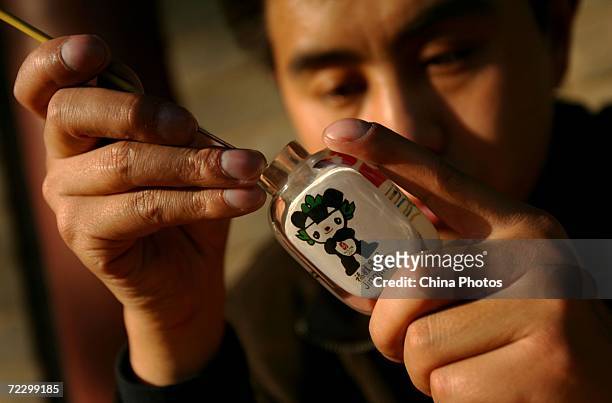 Interior painting artist Li Junyu paints his artwork inside of a snuff bottle October 30, 2006 in Xian of Shaanxi Province, China. The patterns...