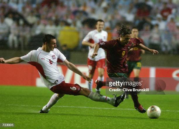 Tomasz Hajto of Poland tackles Joao Pinto of Portugal during the Group D match of the World Cup Group Stage played at the Jeonju World Cup Stadium,...