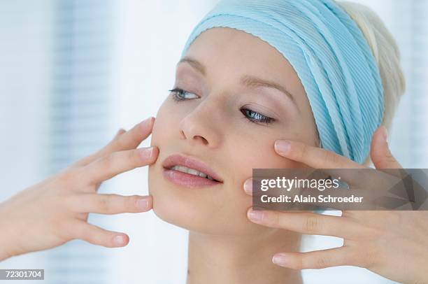young woman face with make up, putting her fingers on her face, close-up (studio) - facelift stock-fotos und bilder