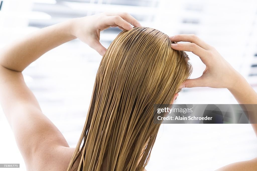 Young woman with wet hair, view from the back, close up (studio)