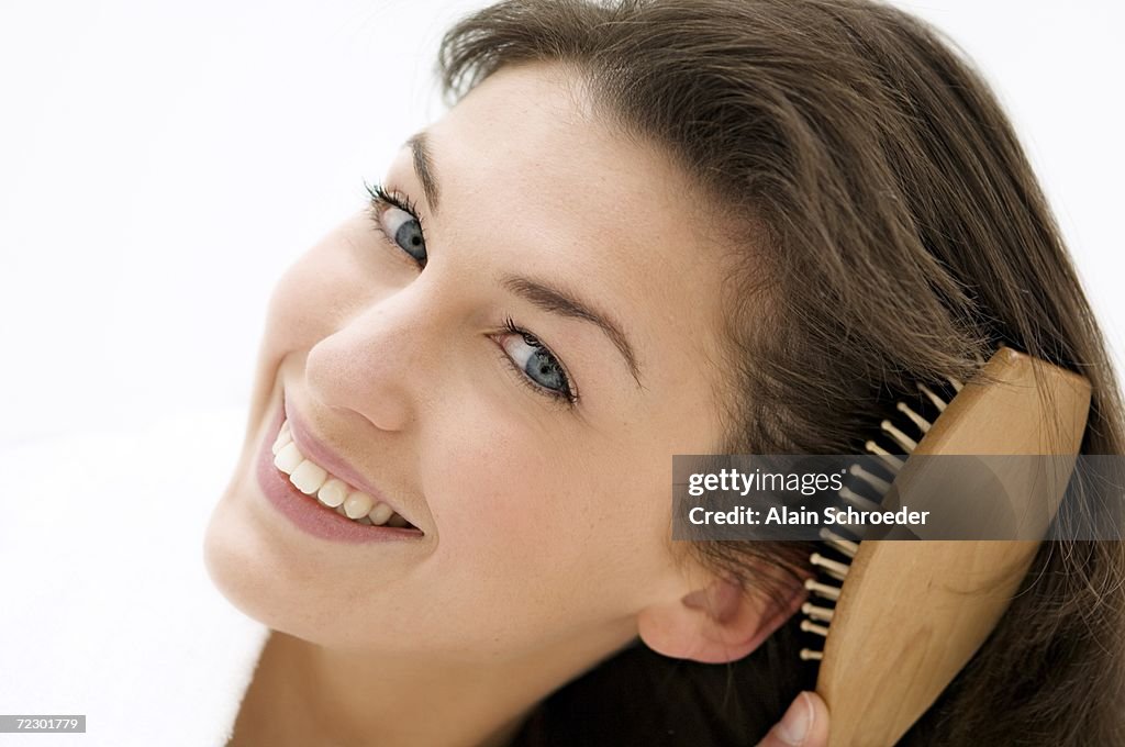 Portrait of a young woman brushing her hair