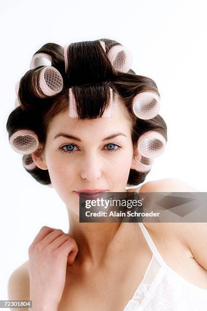 portrait of a young woman in curlers, close up (studio) - hair curlers stockfoto's en -beelden